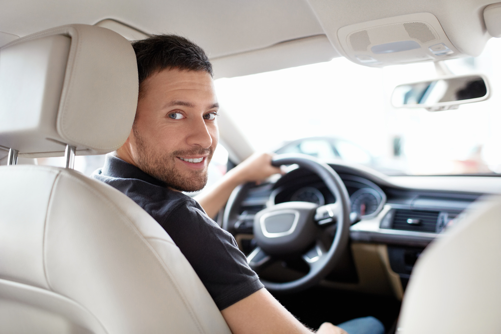 Young male at the wheel enjoying Maximum Collision Valet Service